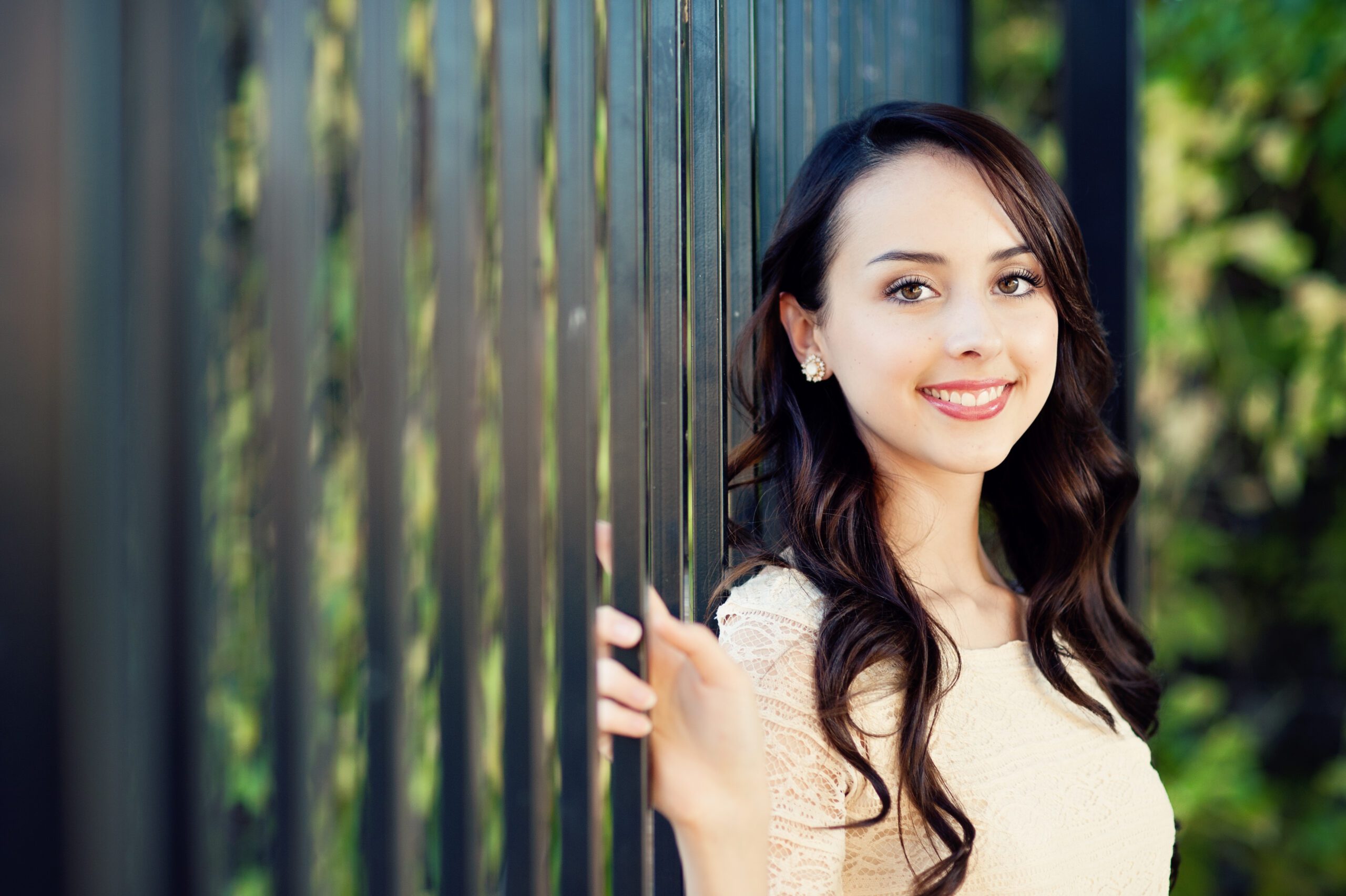 high school senior girl in orlando posing on a black fence for her senior pictures