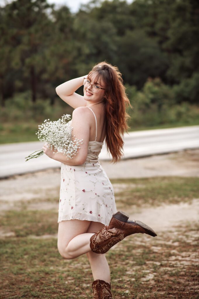 Western-themed senior photo in natural light with soft, earthy color palette