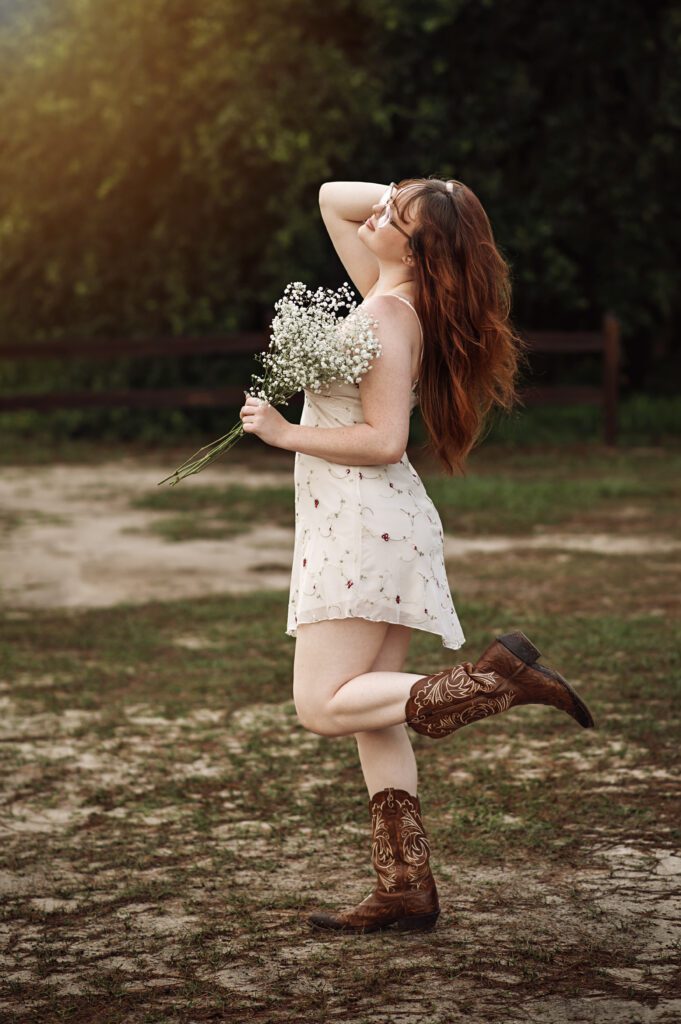 Western-themed senior photo in natural light with soft, earthy color palette