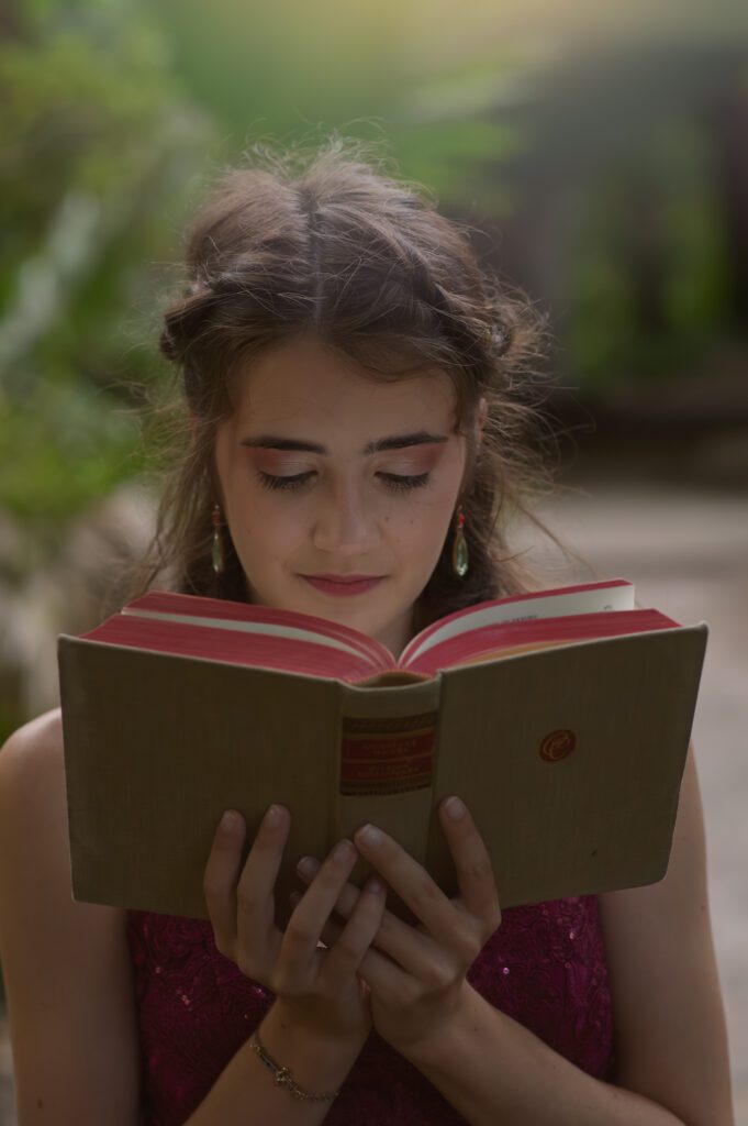 Whimsical portrait of a senior reading a hardcover book in Winter Park, FL