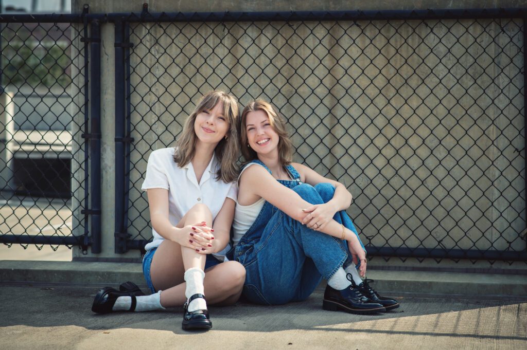 Moody close-up of two girls cheek to cheek, both wearing denim, with smiles