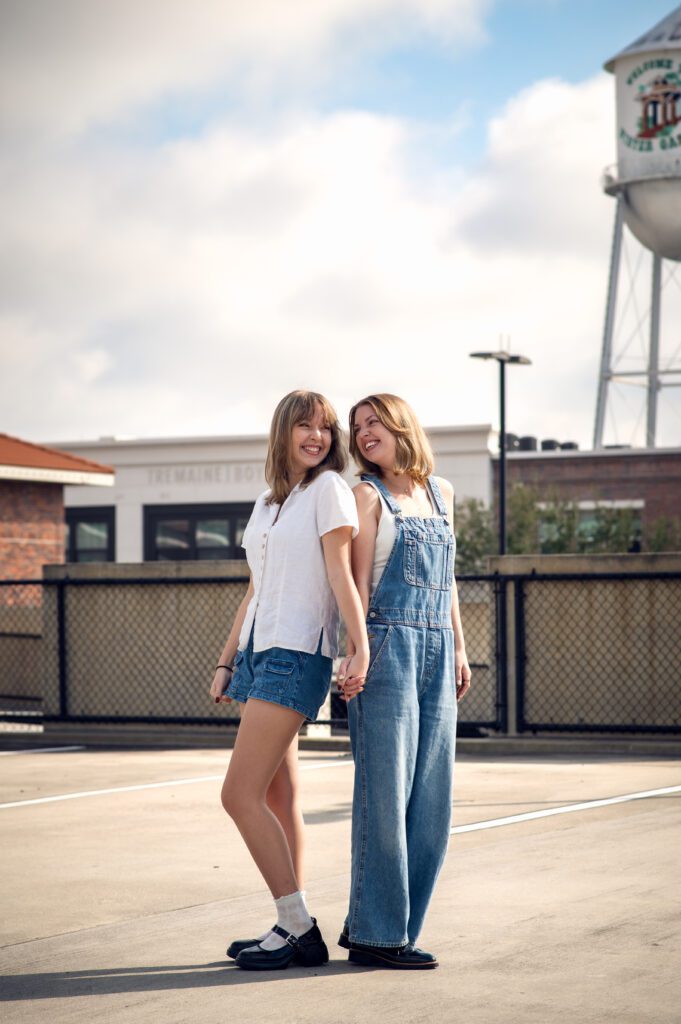 Editorial-style portrait of best friends backlit by the sun, standing on a rooftop in Winter Garden