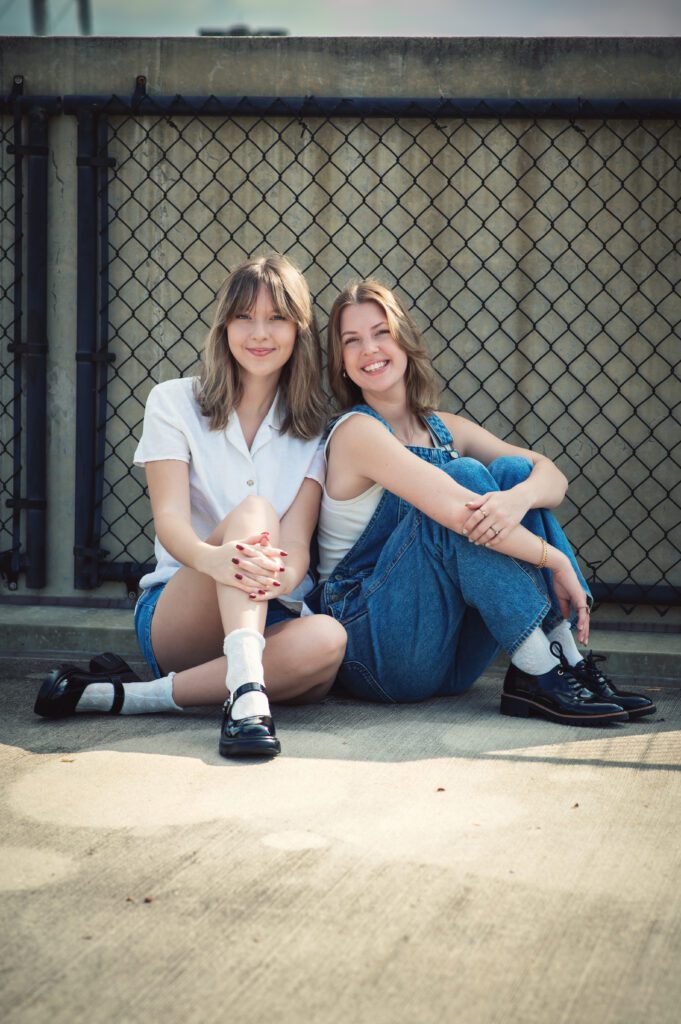 Moody close-up of two girls cheek to cheek, both wearing denim, with big smiles
