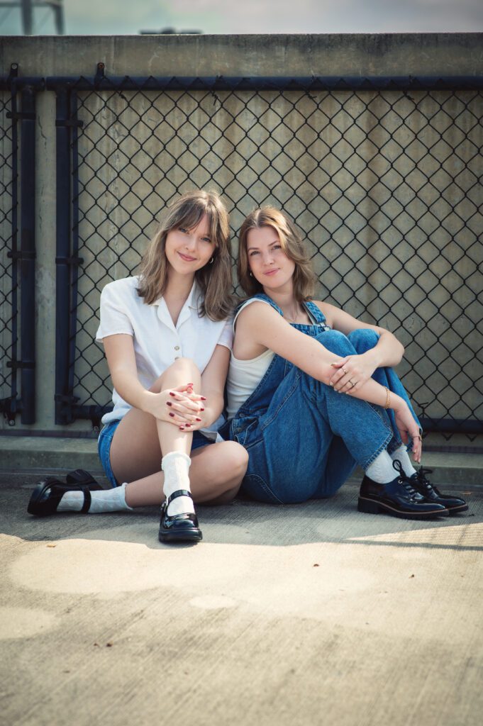 Moody close-up of two girls cheek to cheek, both wearing denim, with soft smiles