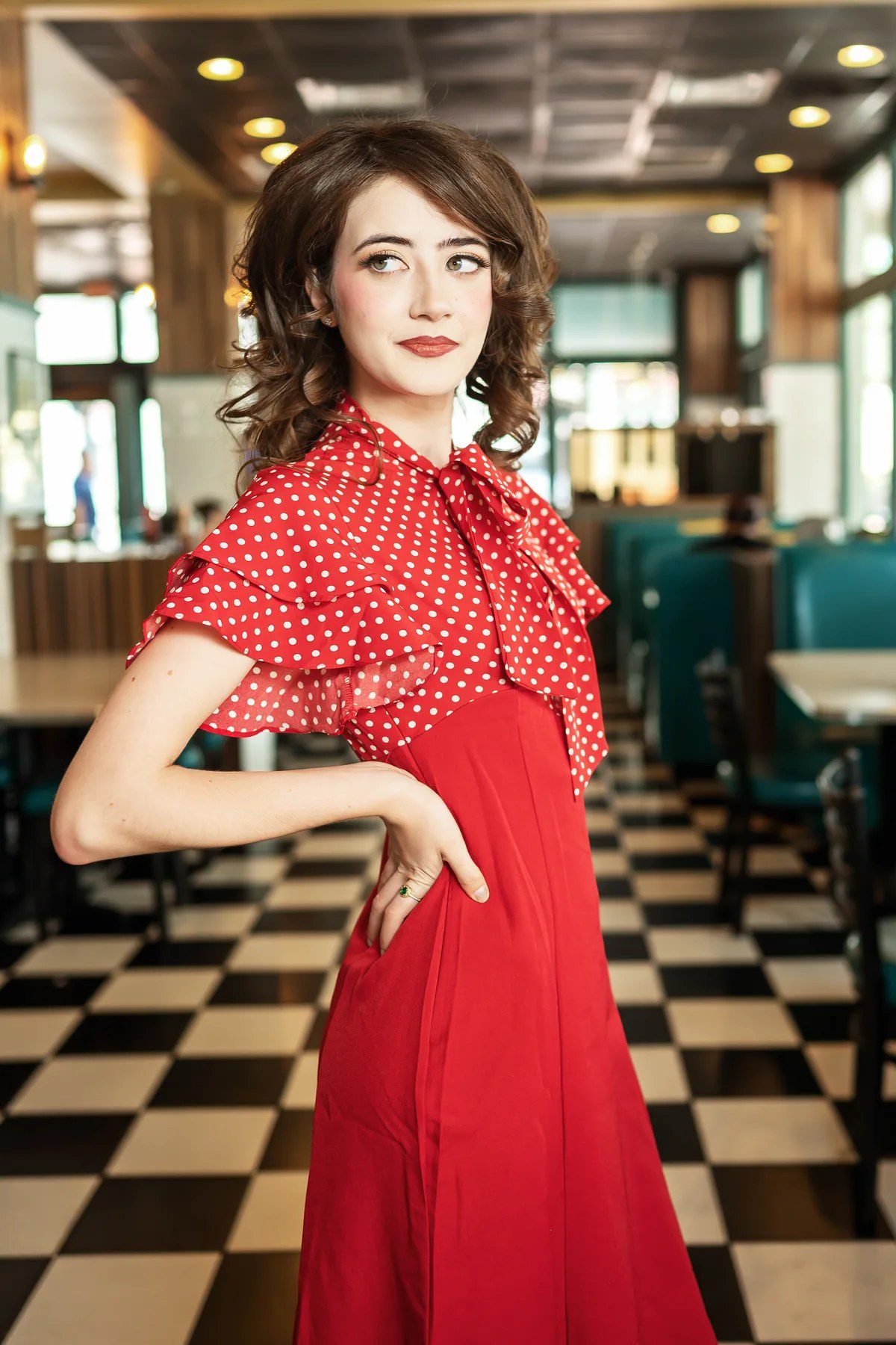 Close senior portrait with 1950s-inspired hair, makeup and red polka-dot dress