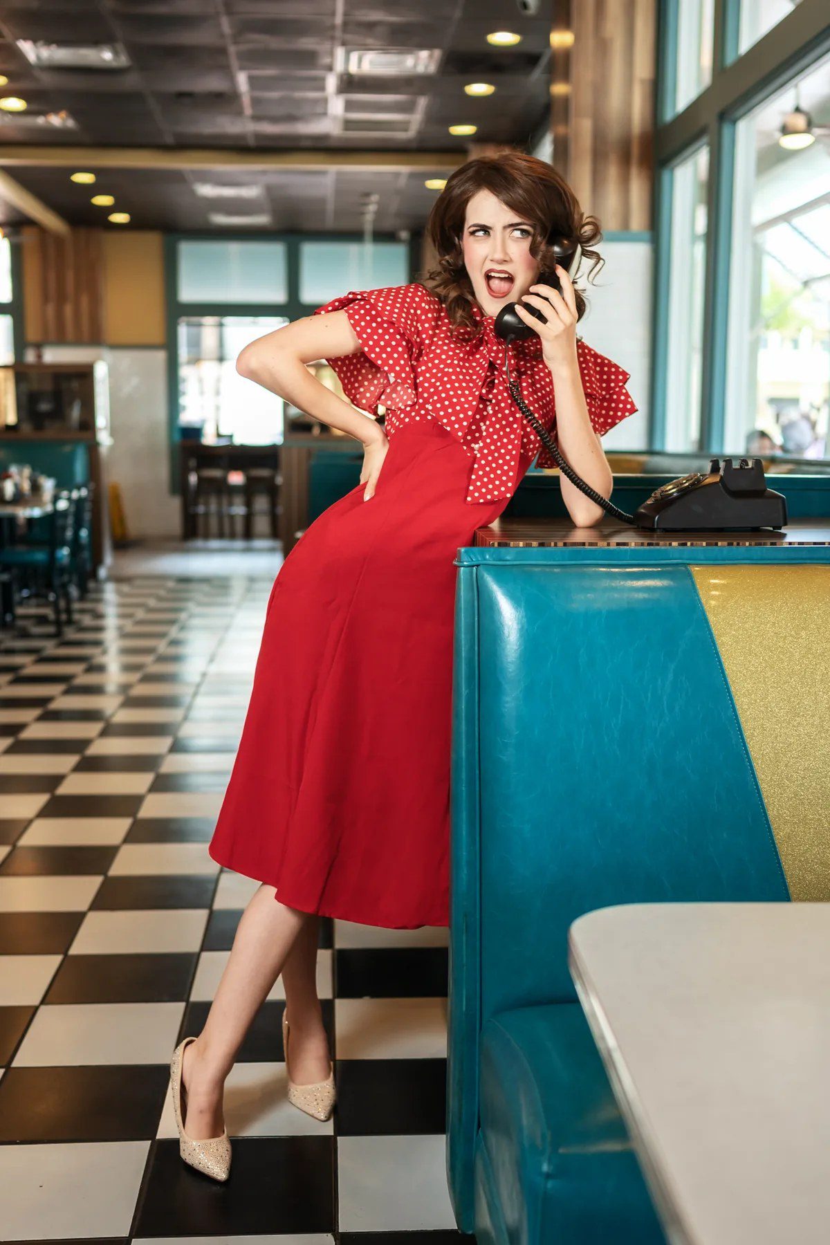Retro diner senior picture with a red dress and vintage phone
