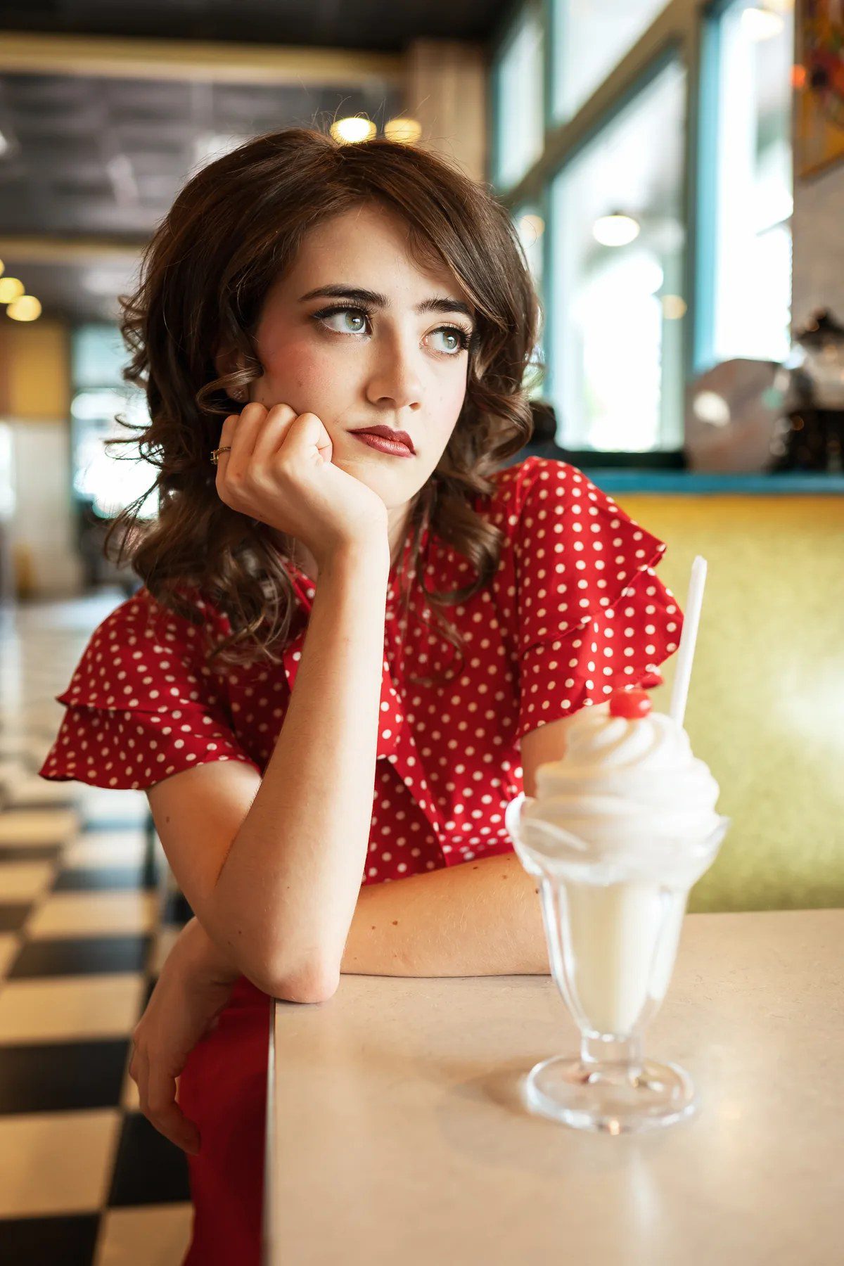 Close senior portrait with an ice cream sundae at a retro diner