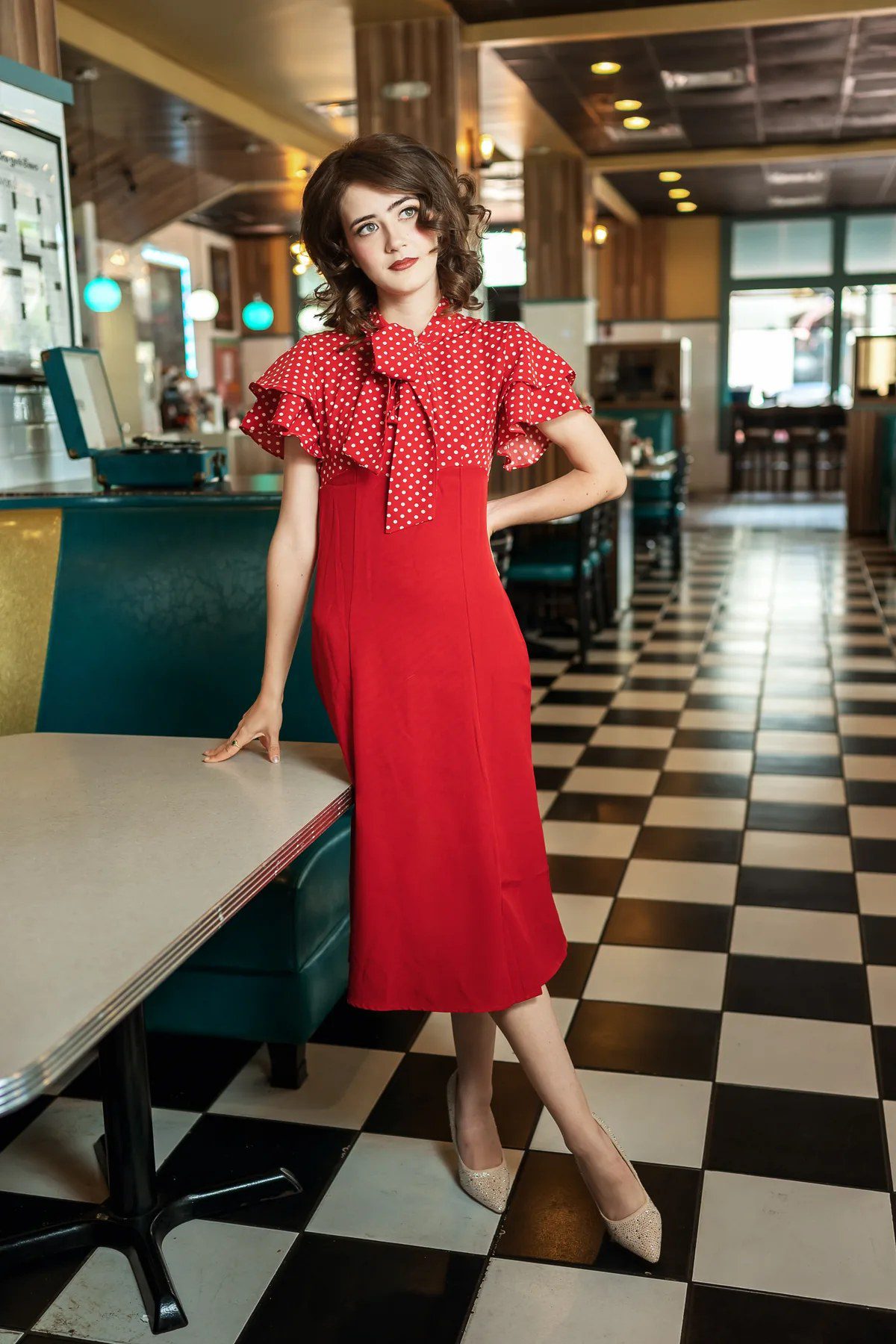 Creative senior pictures in Orlando with a red dress in a retro diner
