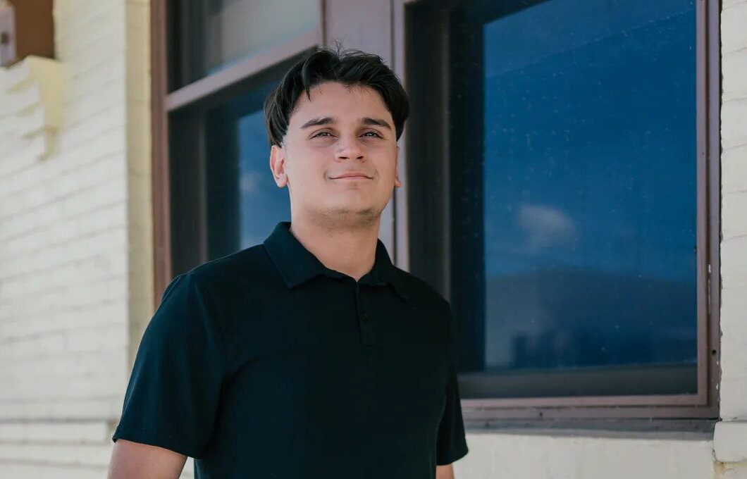 Black shirt senior portrait beside a blue-trimmed building in Downtown Winter Garden