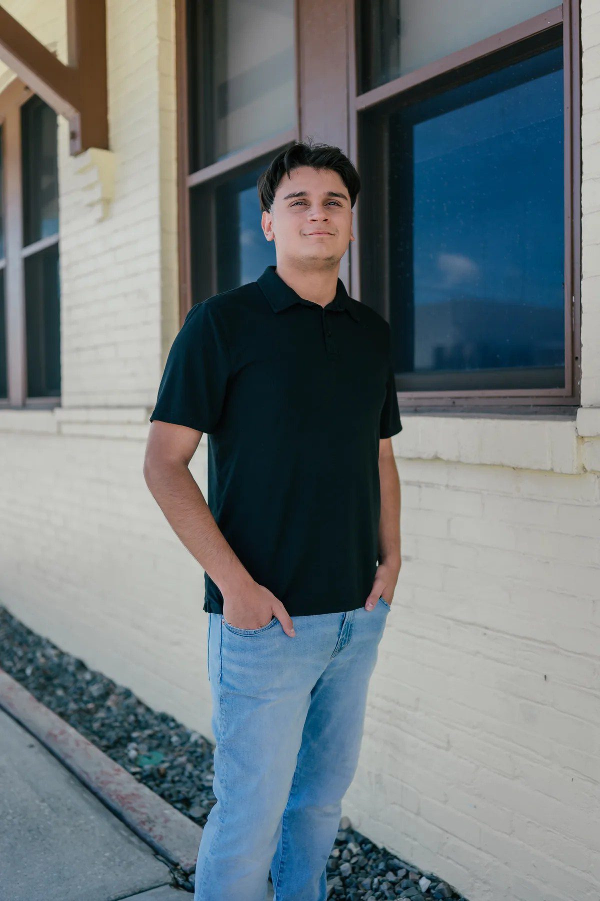 Black shirt senior portrait beside a blue-trimmed building in Downtown Winter Garden
