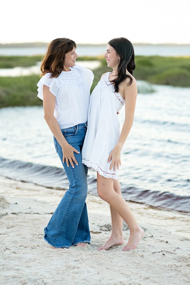 Mother and daughter sharing a candid moment during senior pictures at the beach