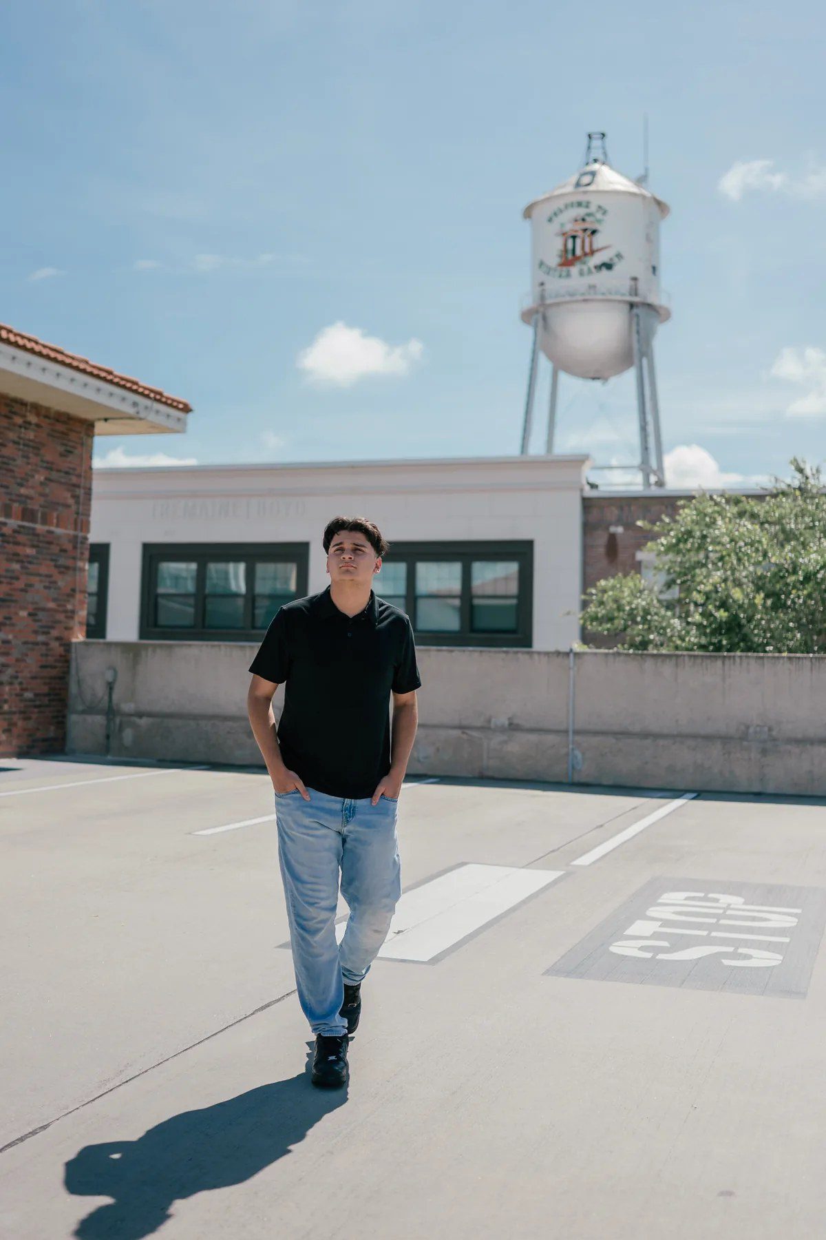 Senior walking across the Downtown Winter Garden parking garage with the water tower behind him
