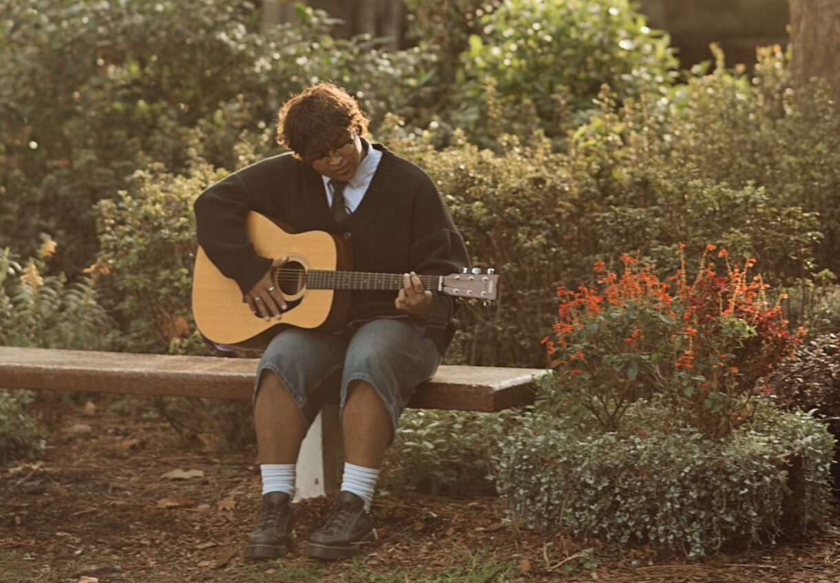 senior guy playing guitar in park in Winter Park, FL
