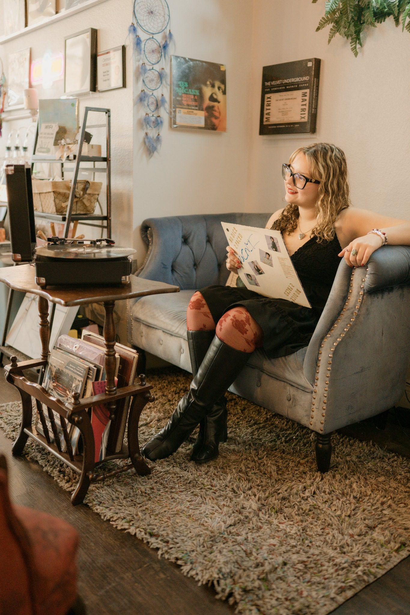 Senior in a black dress posing in a vintage chair near Orlando