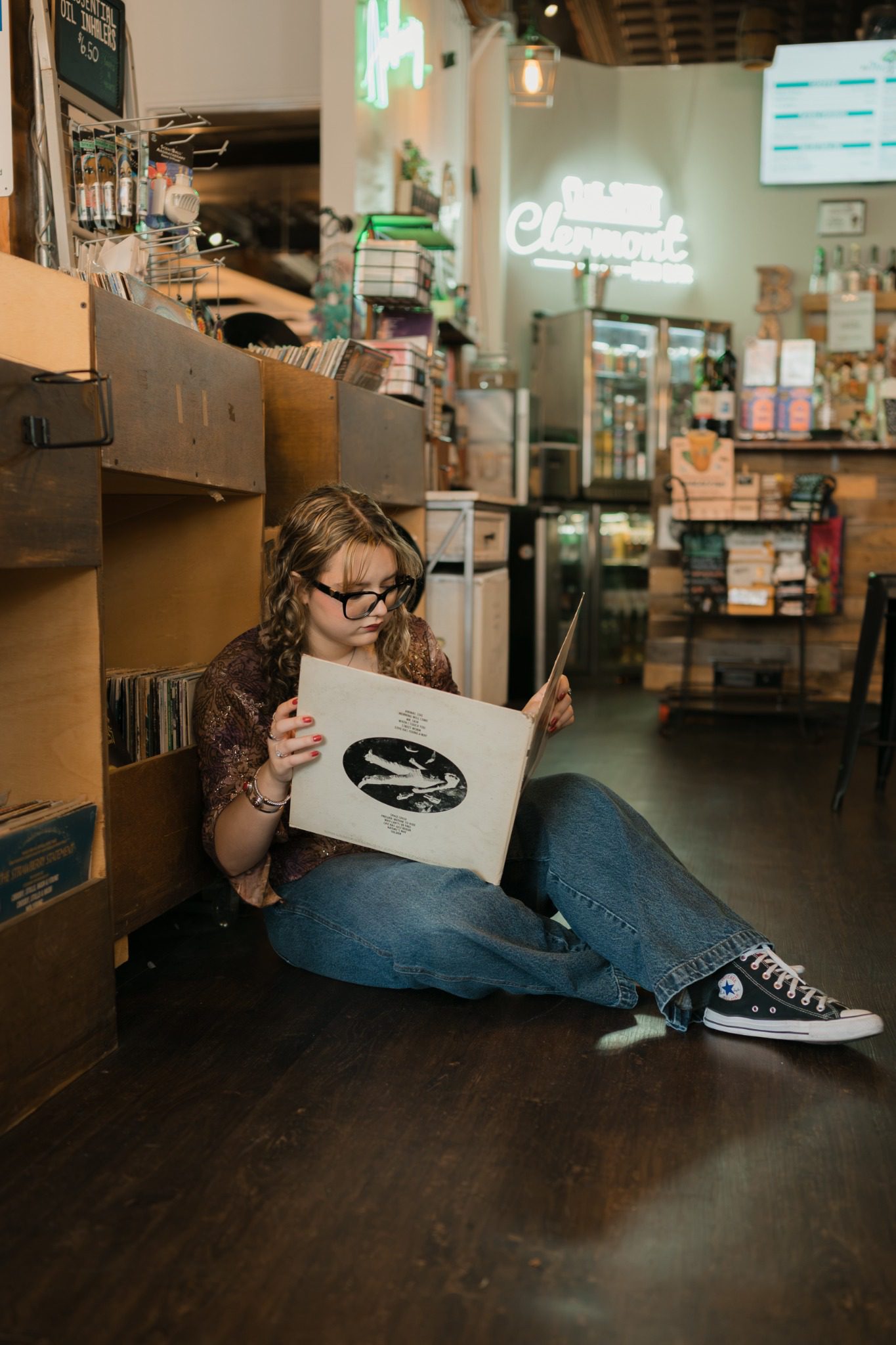 Senior sitting on the floor with vinyl records during a Clermont senior session