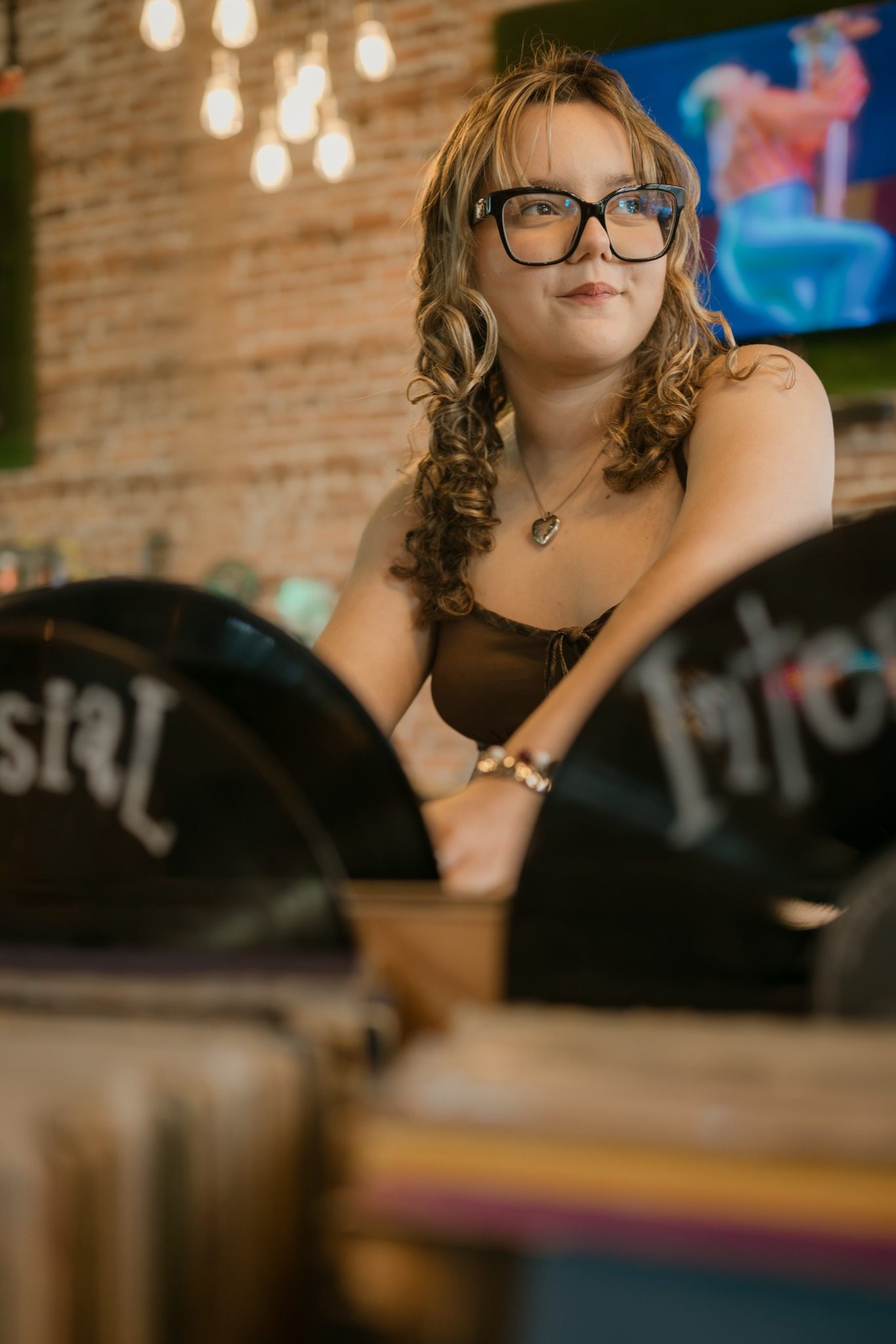 Close senior portrait framed through record bins at a Clermont record store