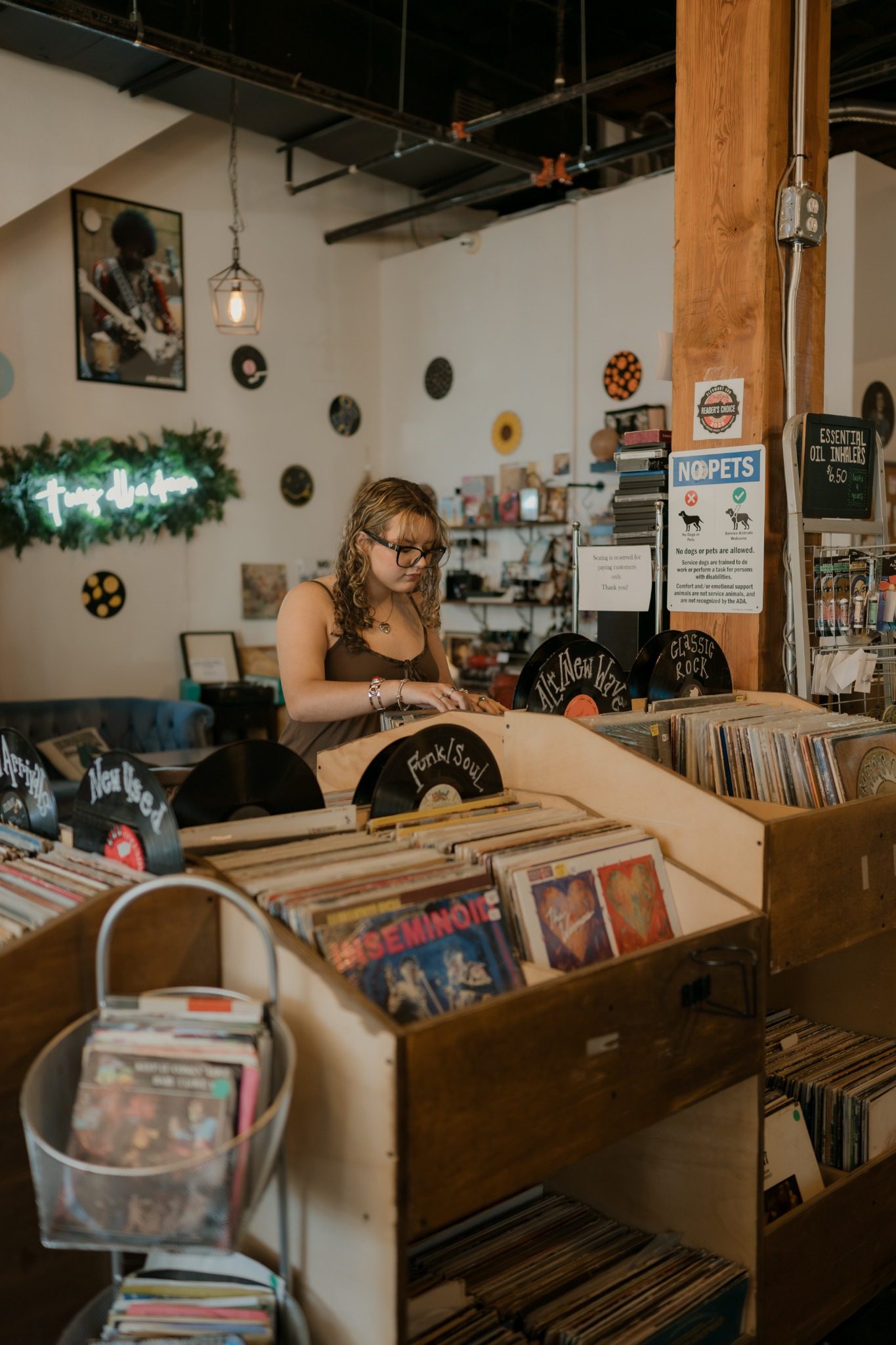Wide view of a senior surrounded by record bins during a Clermont senior photo session