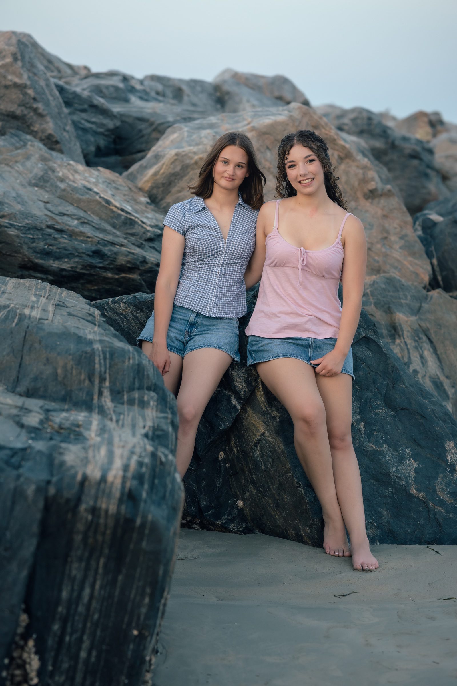 Senior and her best friend standing beside the jetty rocks