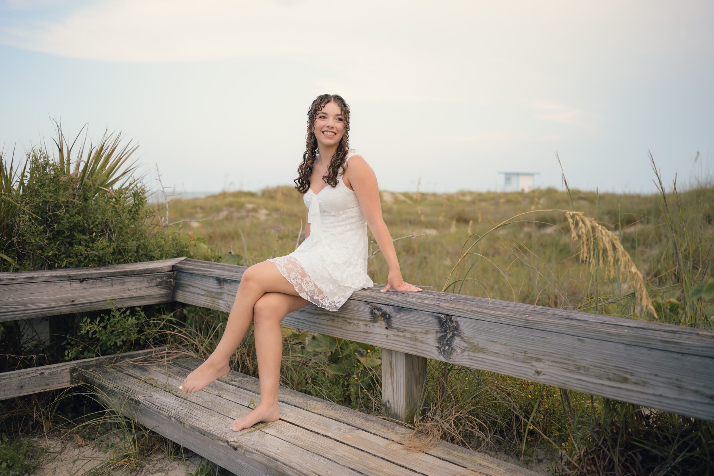 Senior portrait on a wooden beach railing at Jetty Park in Cape Canaveral