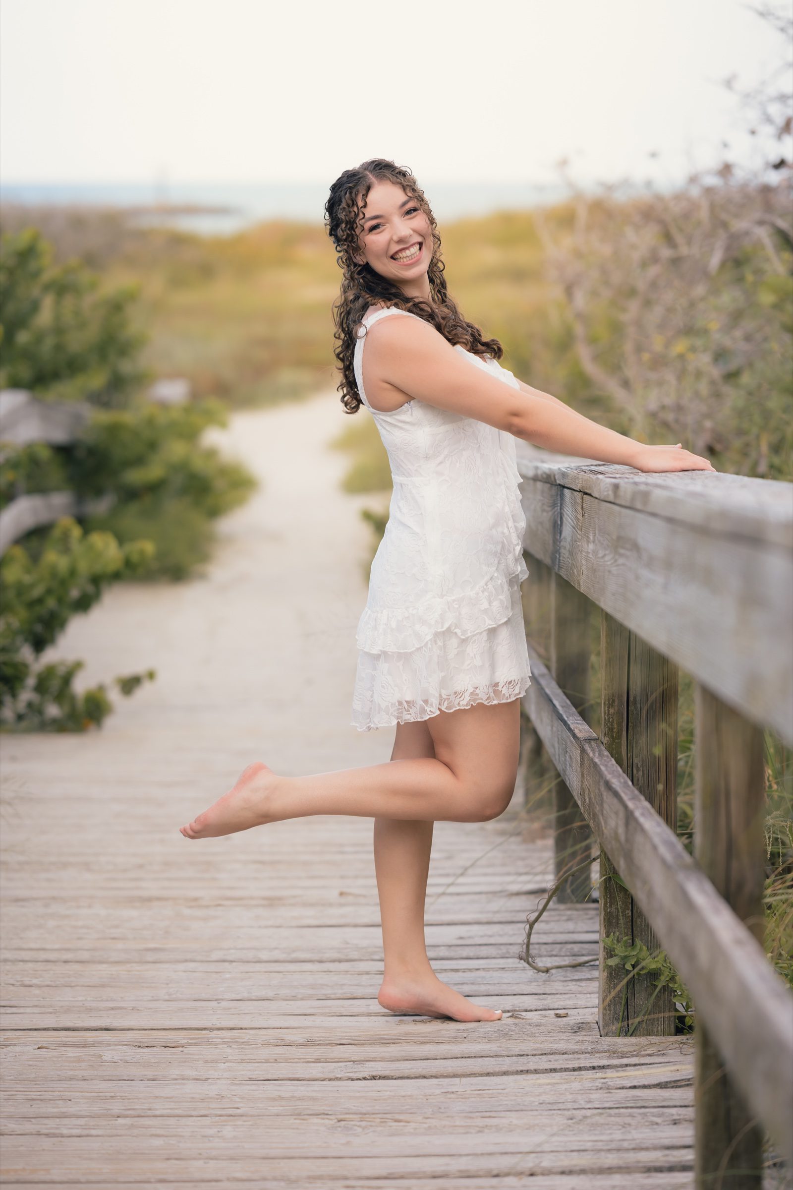 Senior smiling on the boardwalk with one foot lifted