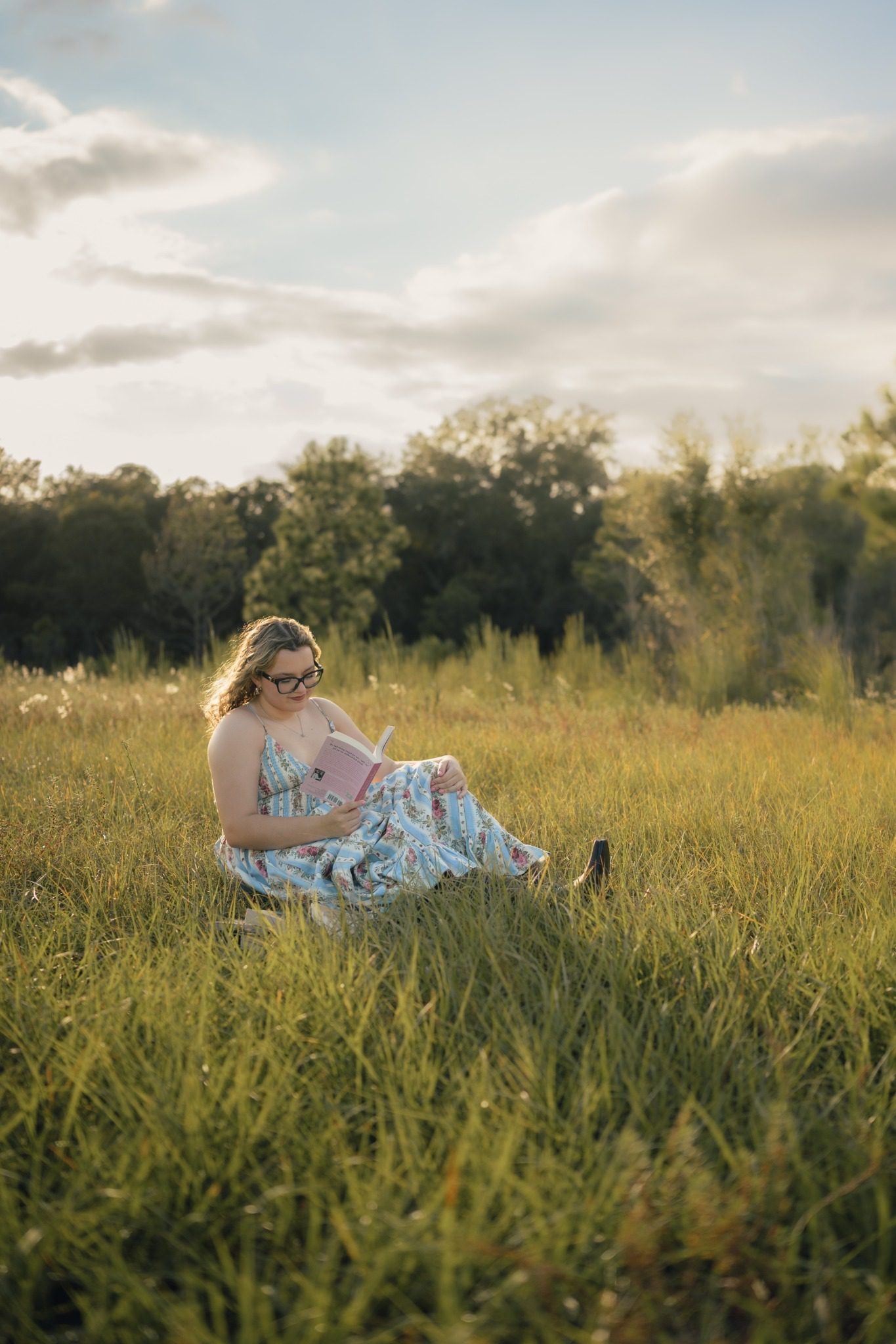 Senior reading a book in an open field at Lake Louisa State Park in Clermont