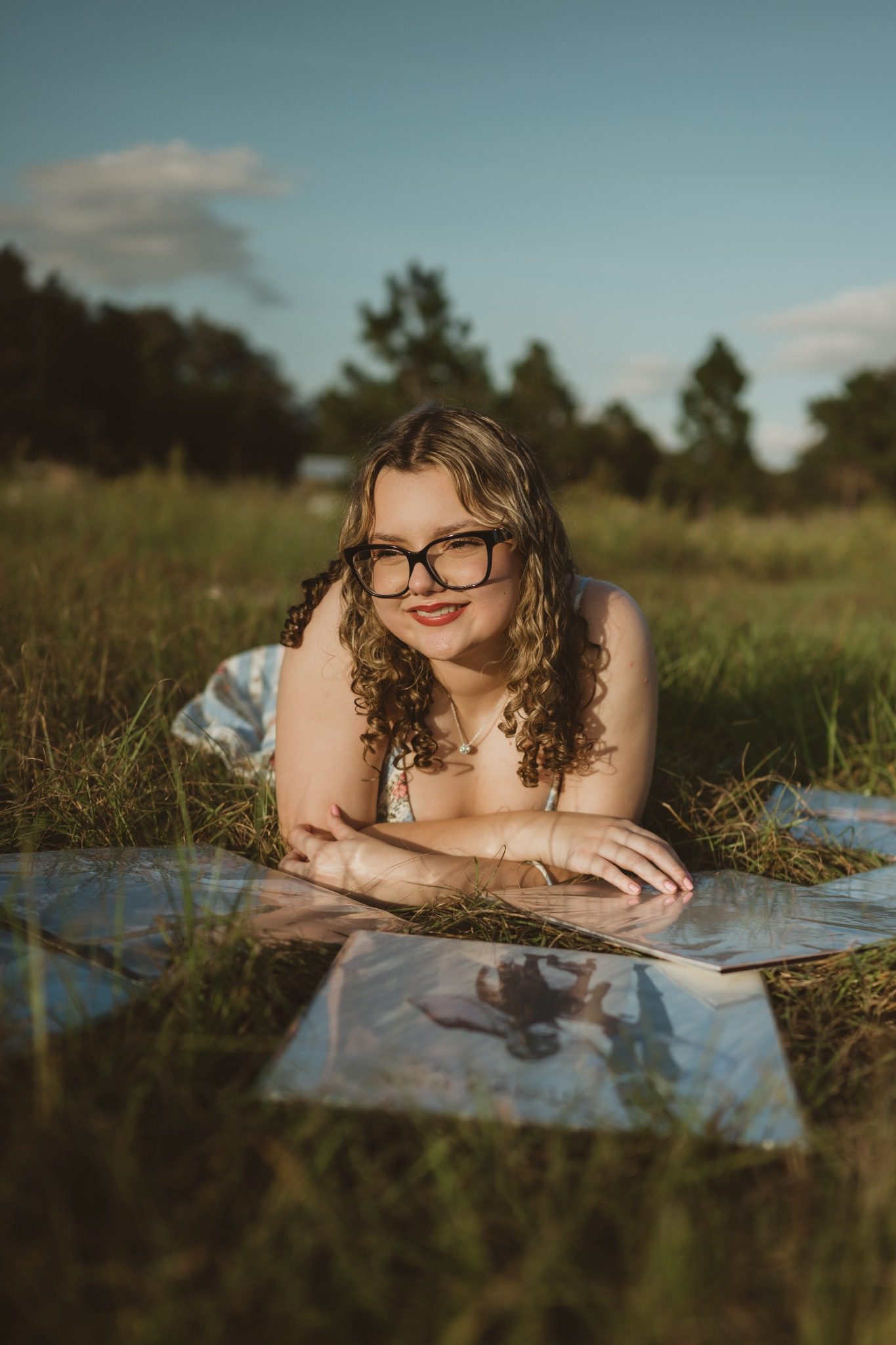 Senior holding vinyl records in a grassy field at Lake Louisa in Clermont