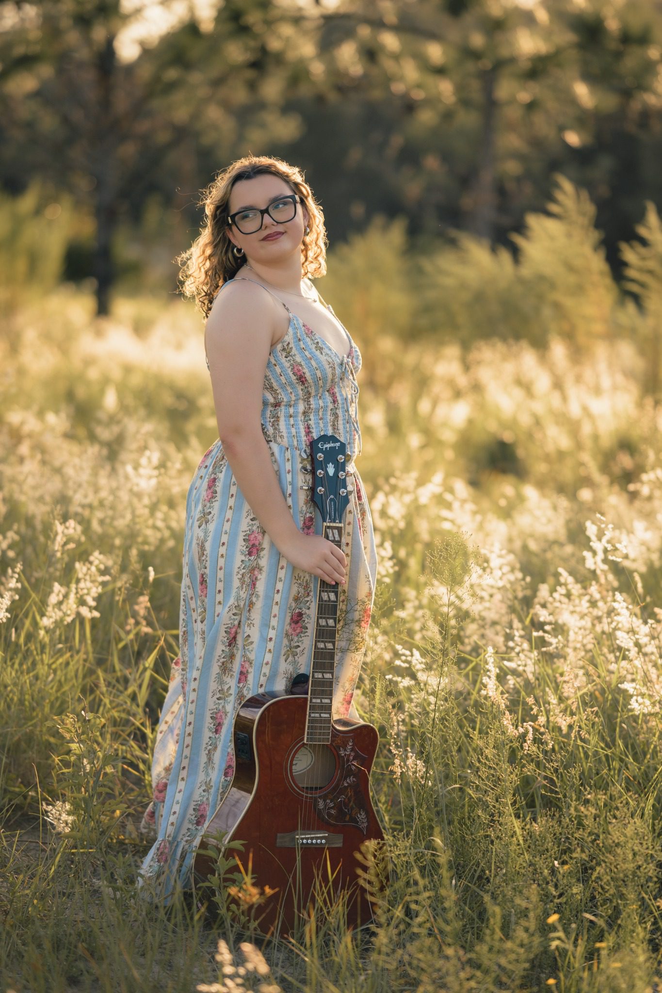 Senior standing with a guitar in evening light at Lake Louisa in Clermont