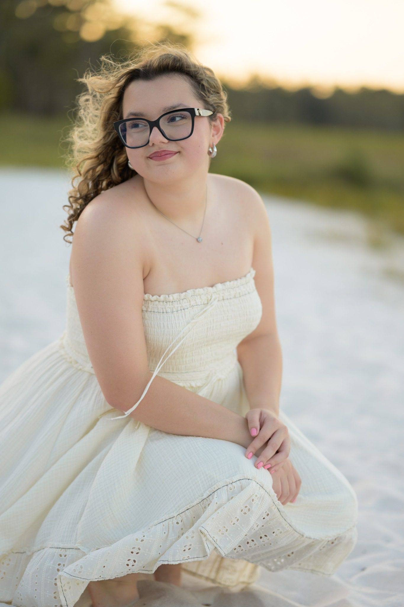 Senior in a white dress near the water at Lake Louisa State Park in Clermont