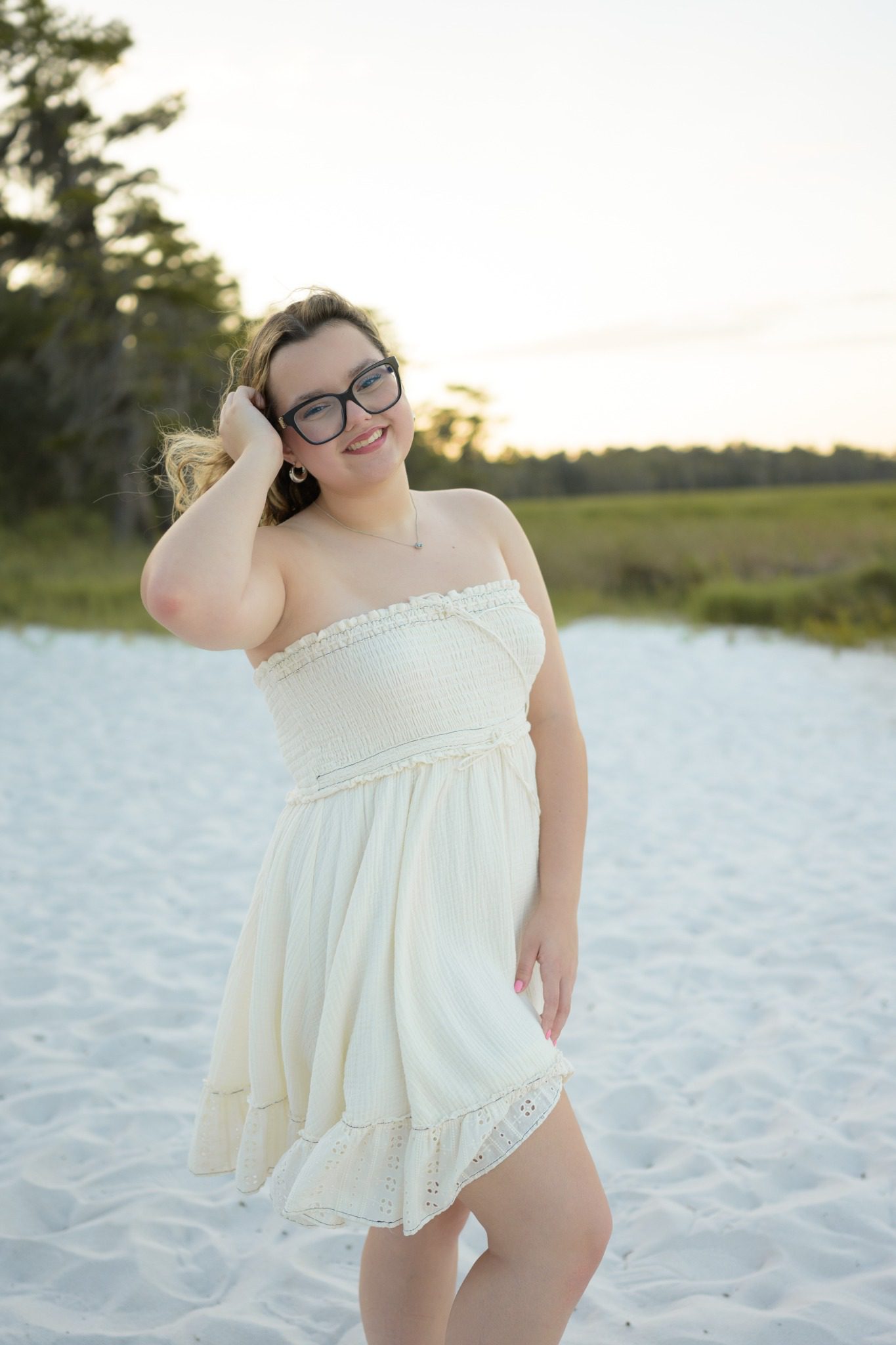 Senior portrait in a white dress beside Lake Louisa in Clermont, Florida