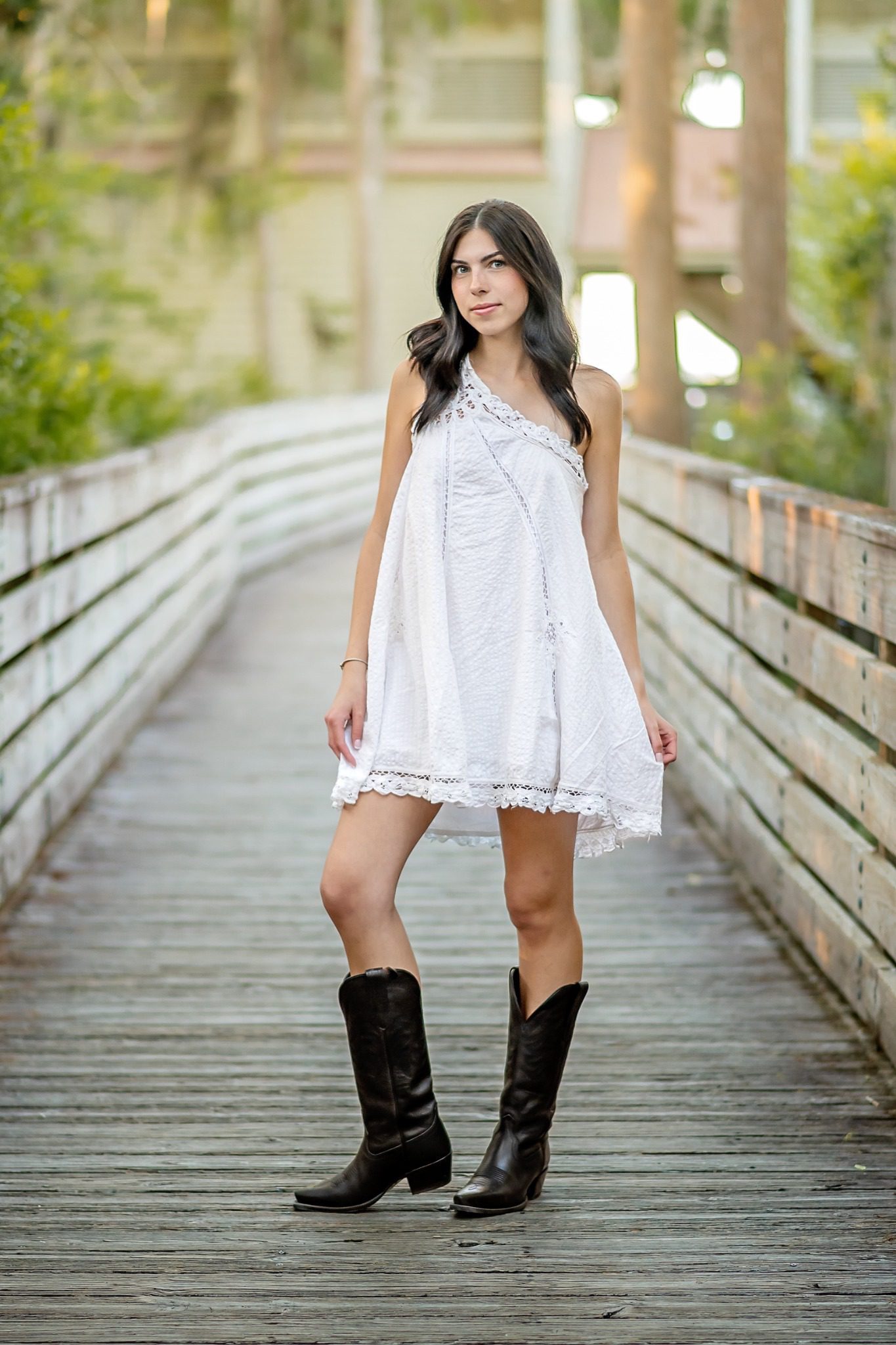 Senior portrait on a wooden boardwalk surrounded by trees at Lake Louisa State Park