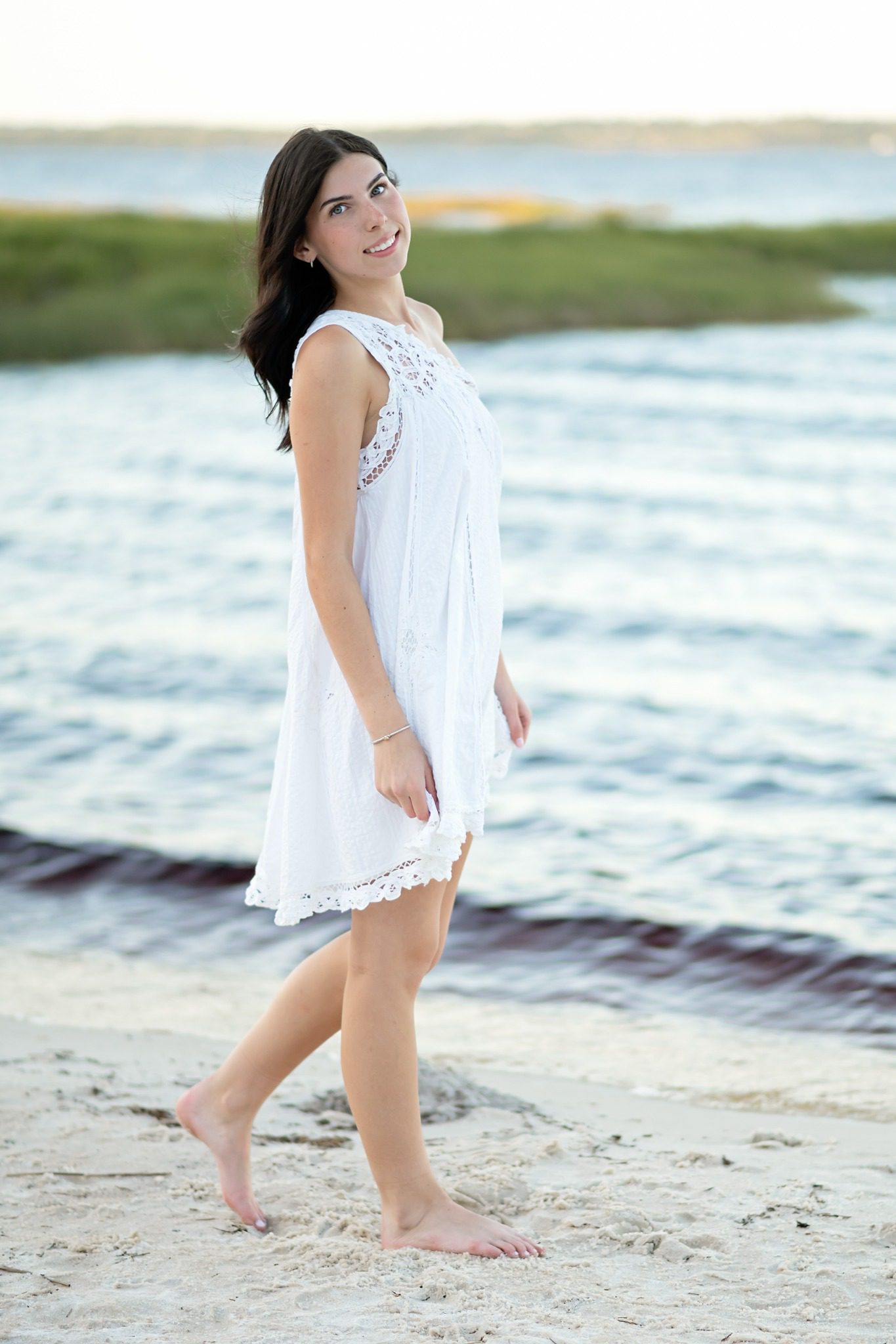 Senior looking over her shoulder while walking along the Lake Louisa beach